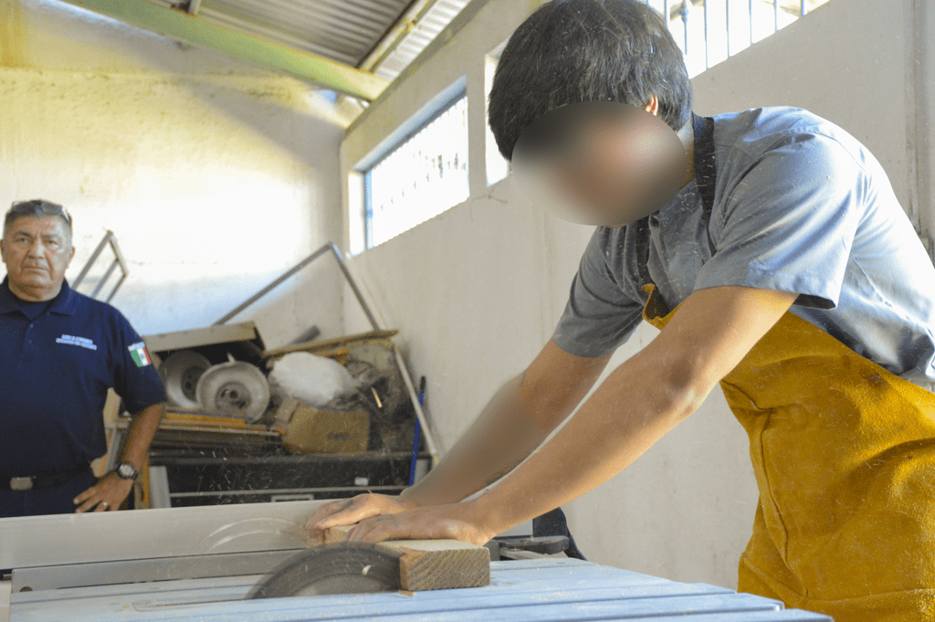 Tres jóvenes participan en un taller de seis meses para aprender a elaborar muebles y otros artículos de madera como parte de su proceso de reinserción social.